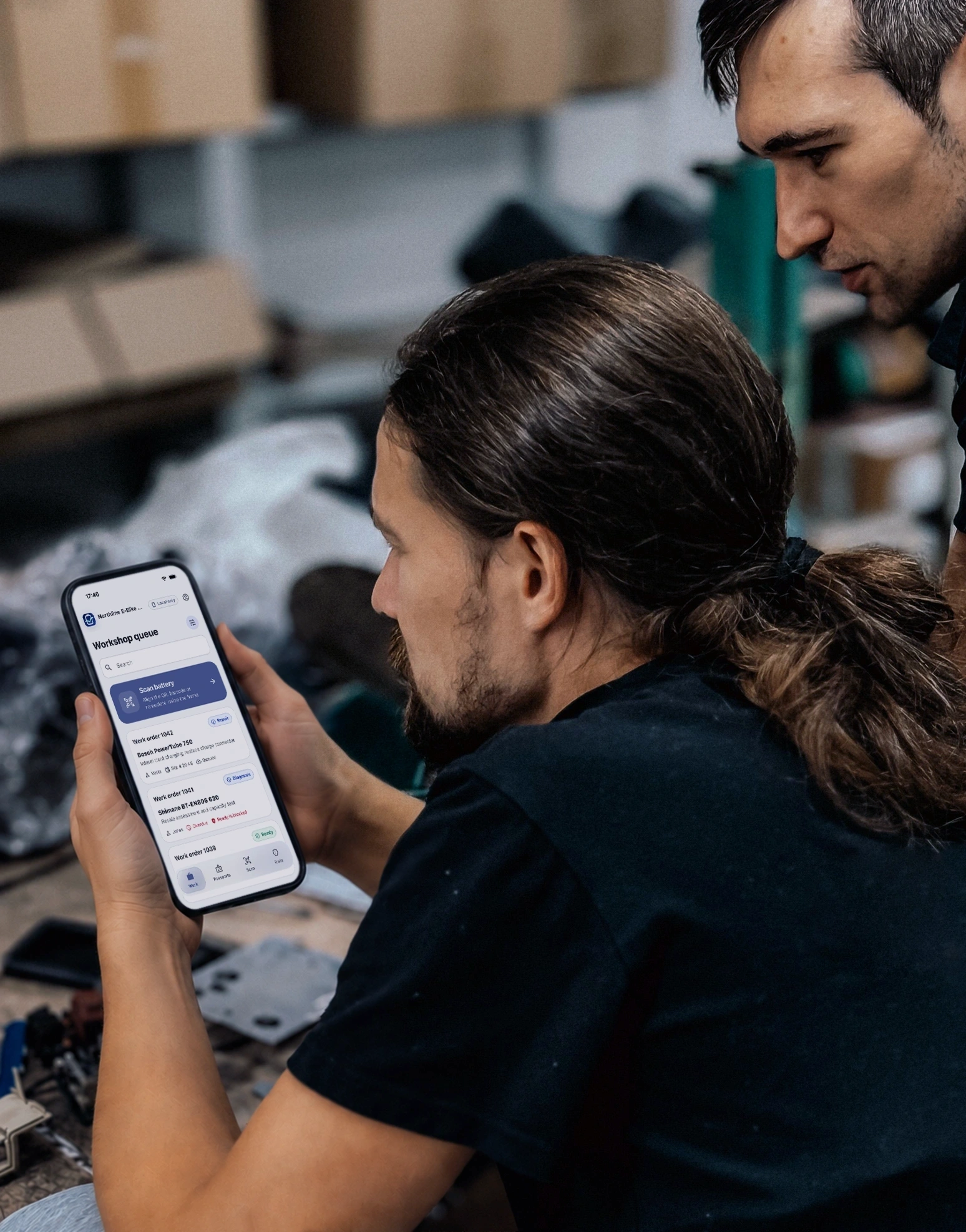 Dva baterioví technici kontrolují diagnostiku na tabletu v profesionální dílně